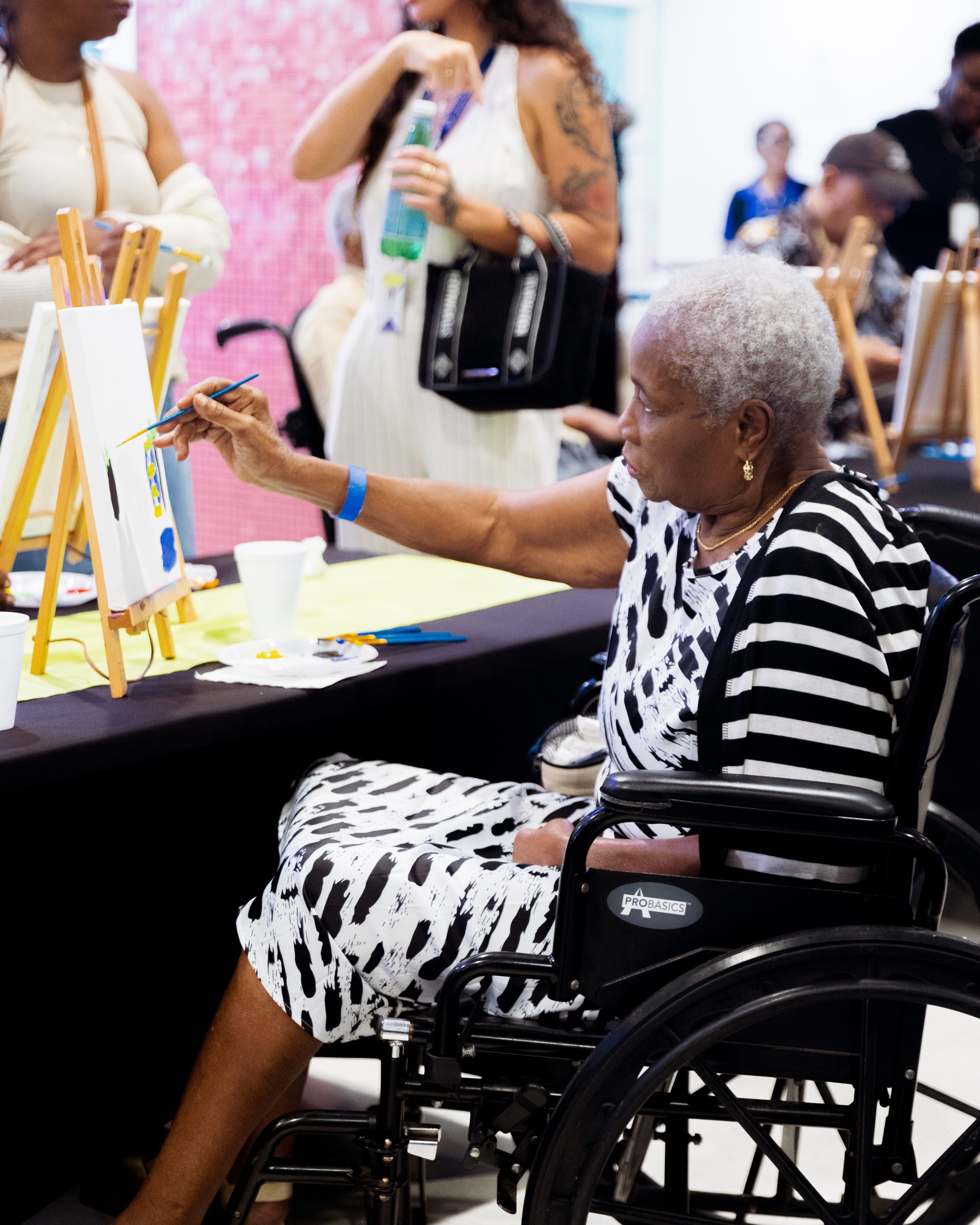 a woman in a wheelchair painting