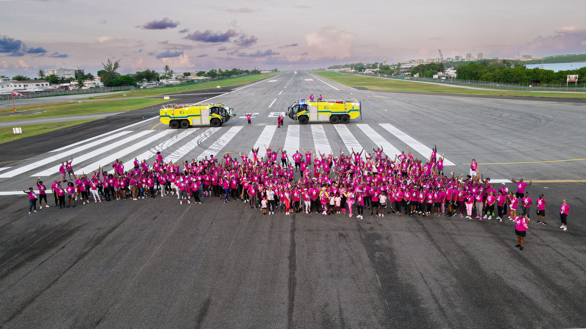 a group of people in pink shirts standing in front of a truck