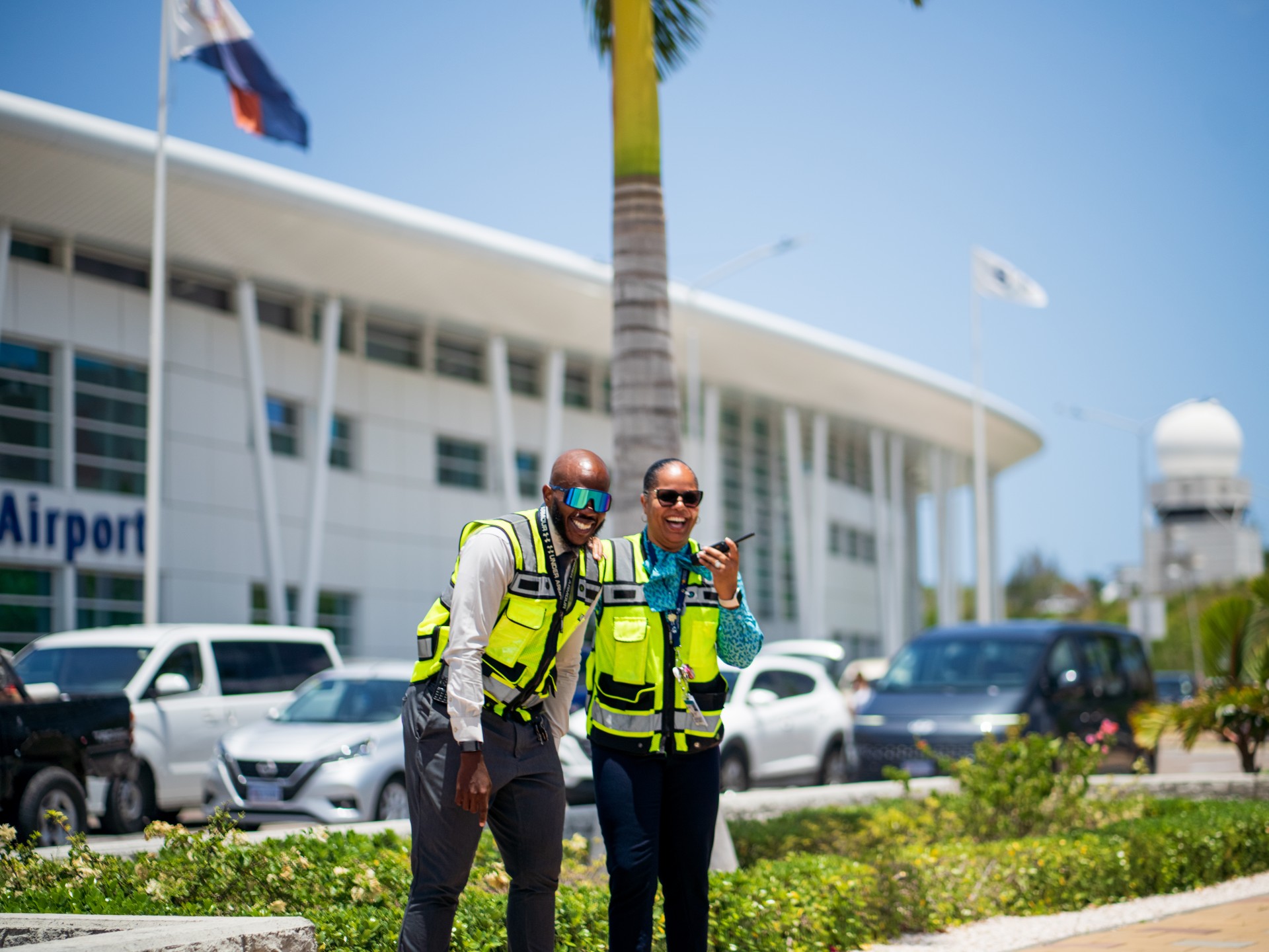 two men wearing reflective vests standing in front of a building