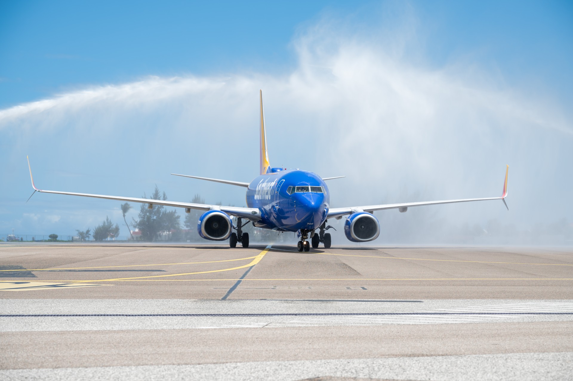 a blue airplane on a runway