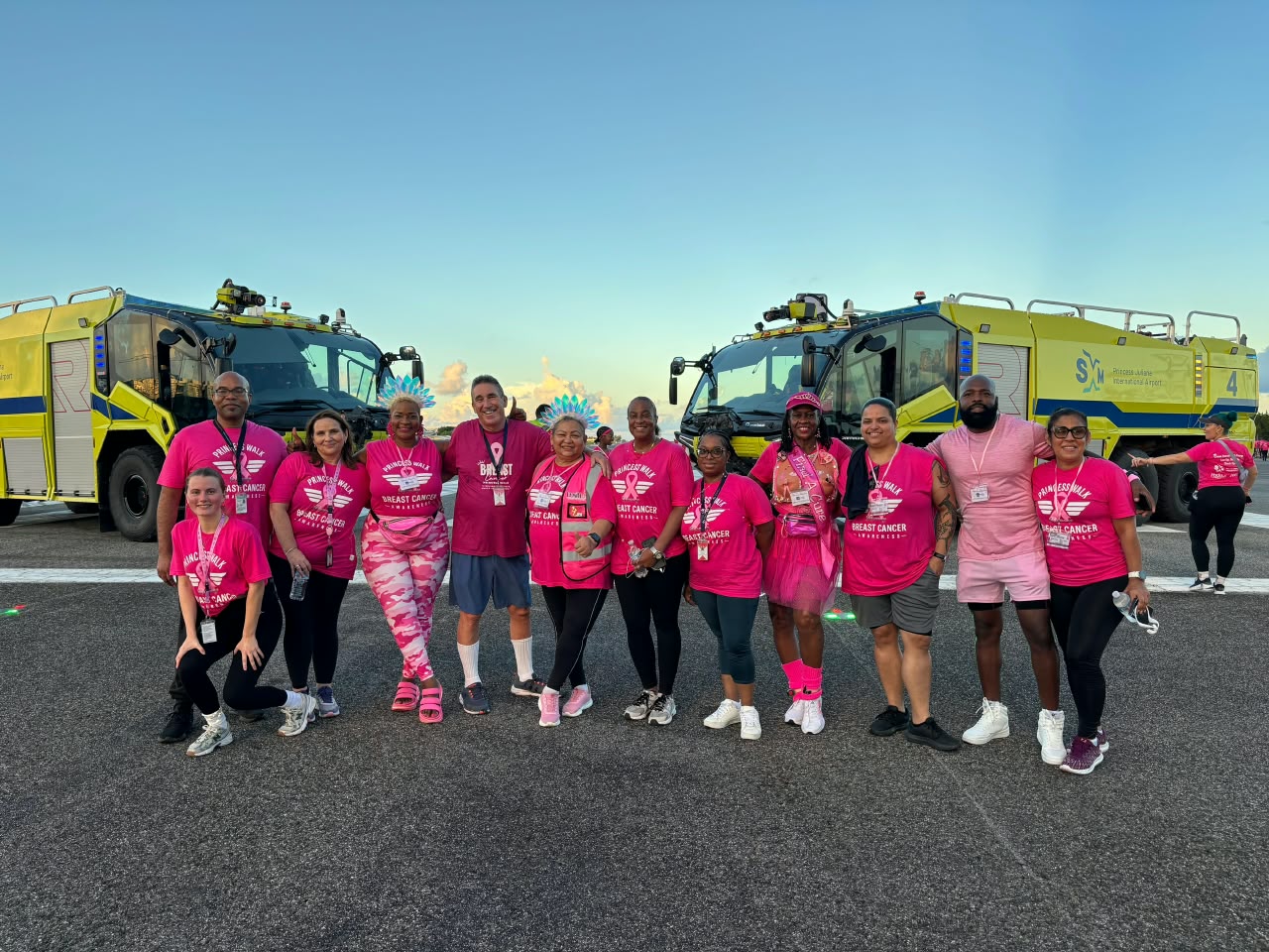 a group of people in pink shirts with Cadillac Ranch in the background