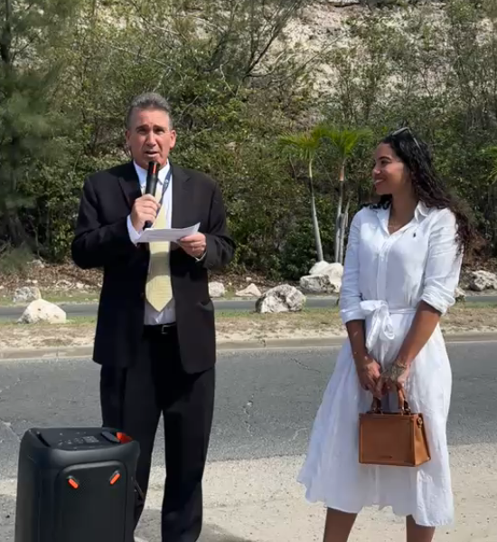 a man in a suit holding a microphone and standing next to a woman