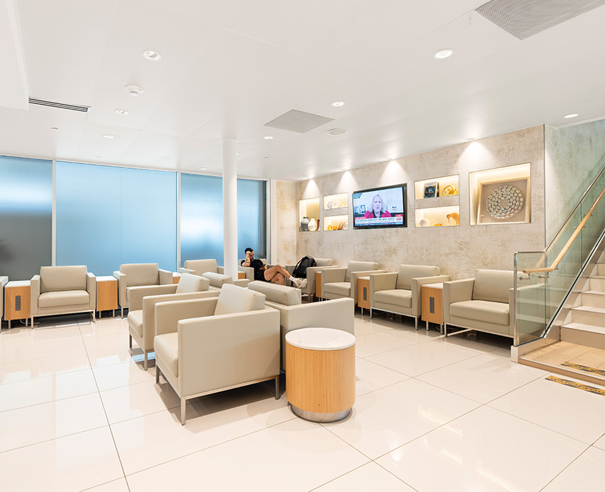 a room with white chairs and a man sitting in a chair