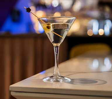 a martini glass with olives on a stick