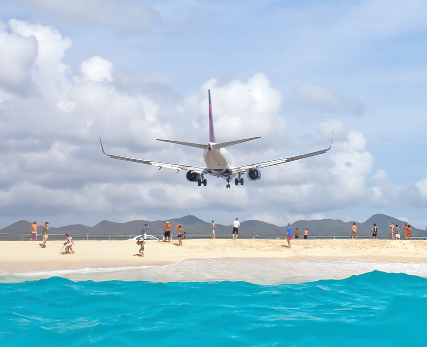 a plane flying over a beach