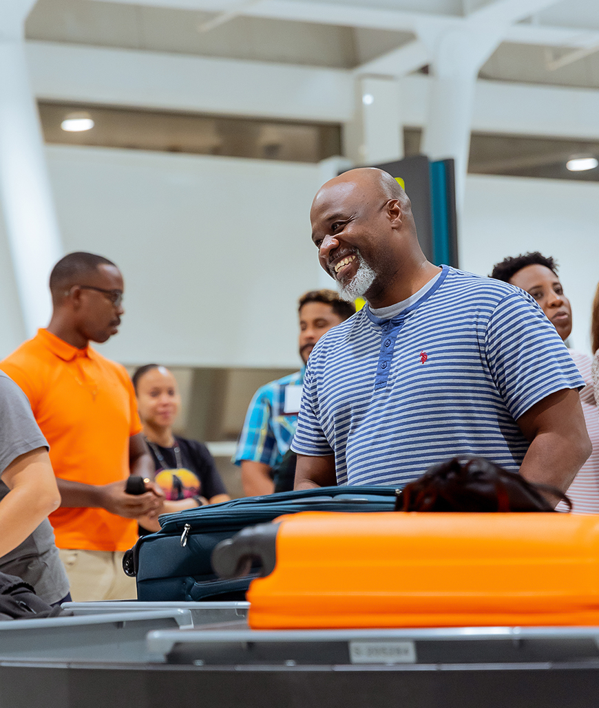 a group of people standing around a luggage cart