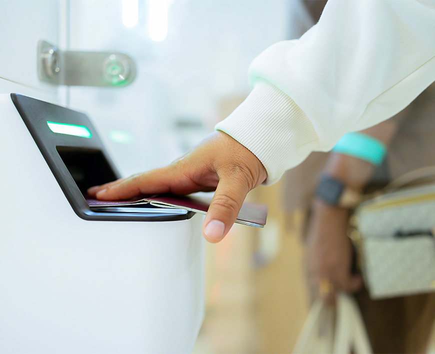 a person's hand inserting a card into a machine