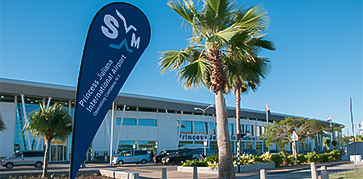 a sign with palm trees in front of a building