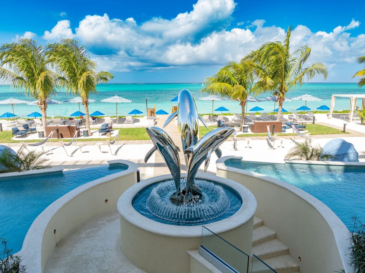 a pool with a fountain and a couple of dolphins