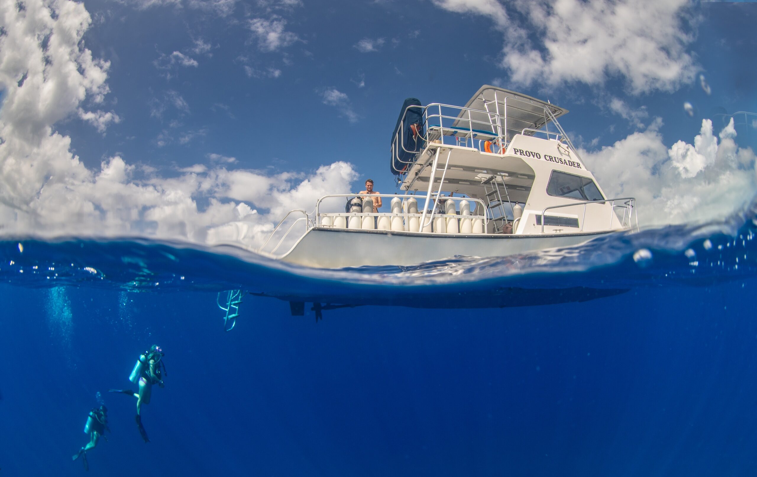 a scuba diver swimming in the water with a boat