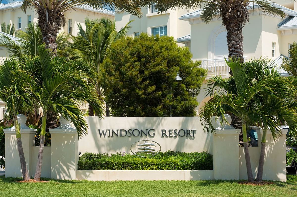 a sign with palm trees in front of a building
