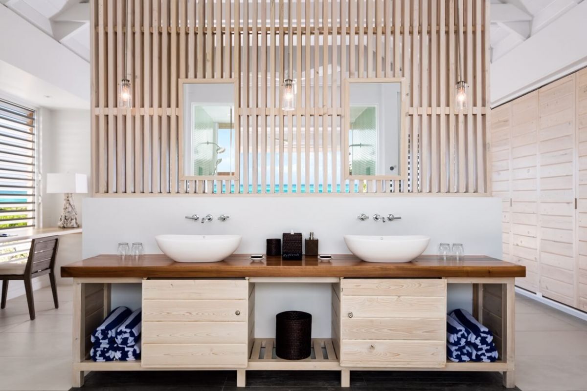 a bathroom with double sinks and wooden cabinets