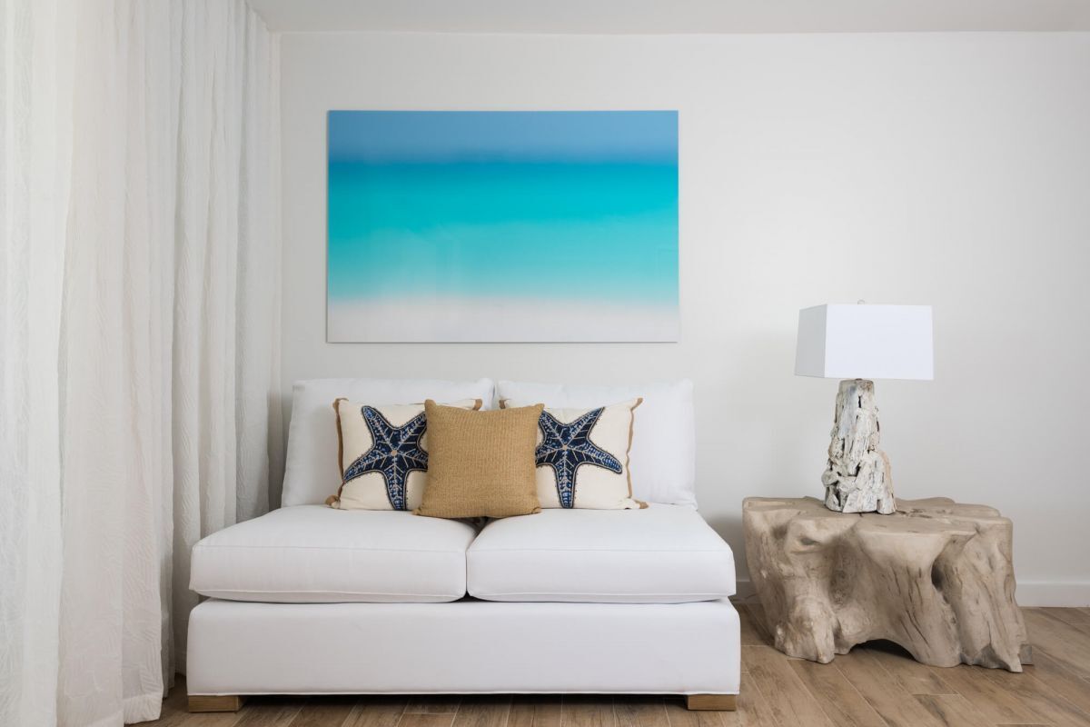 a white couch with pillows and a lamp on a table