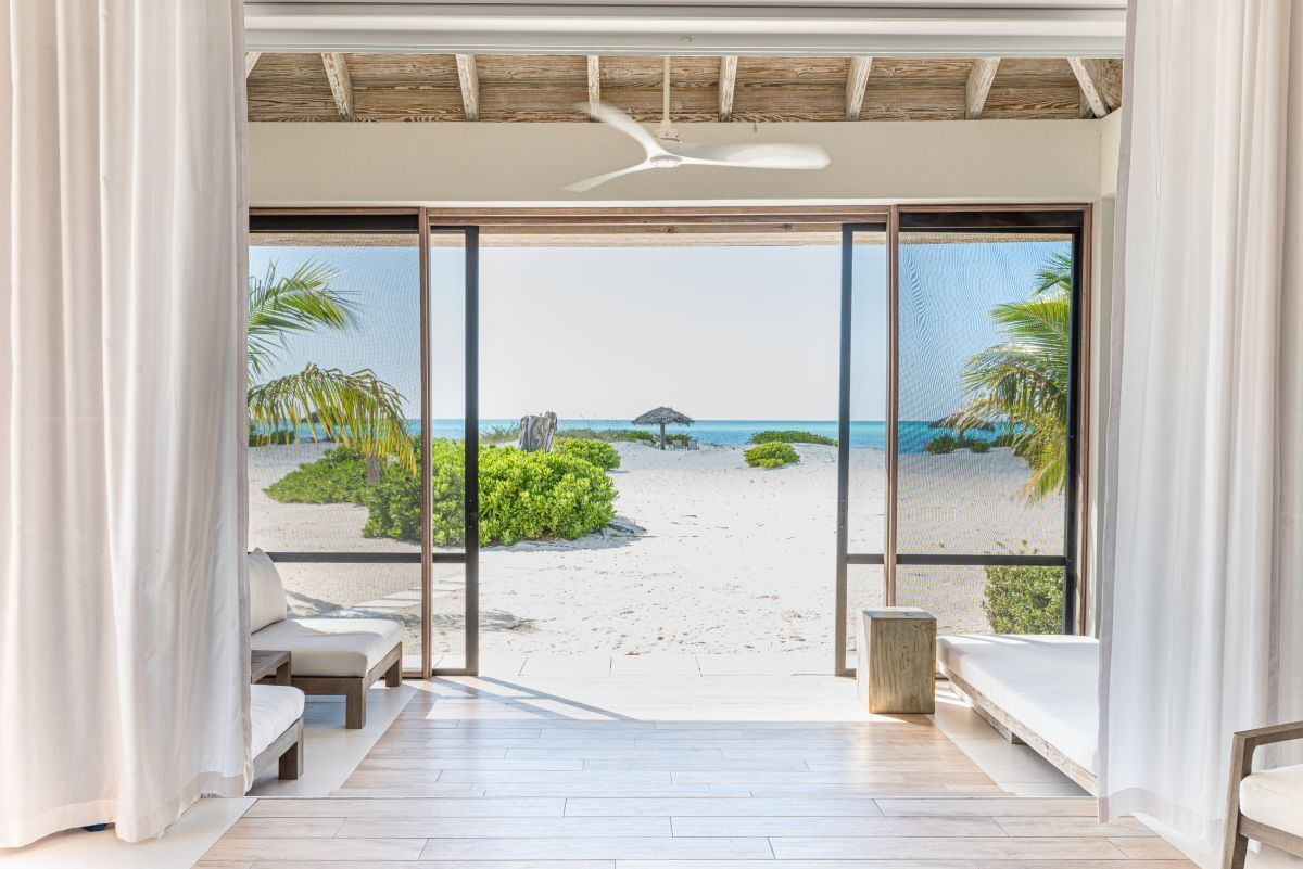 a room with a view of the beach and palm trees