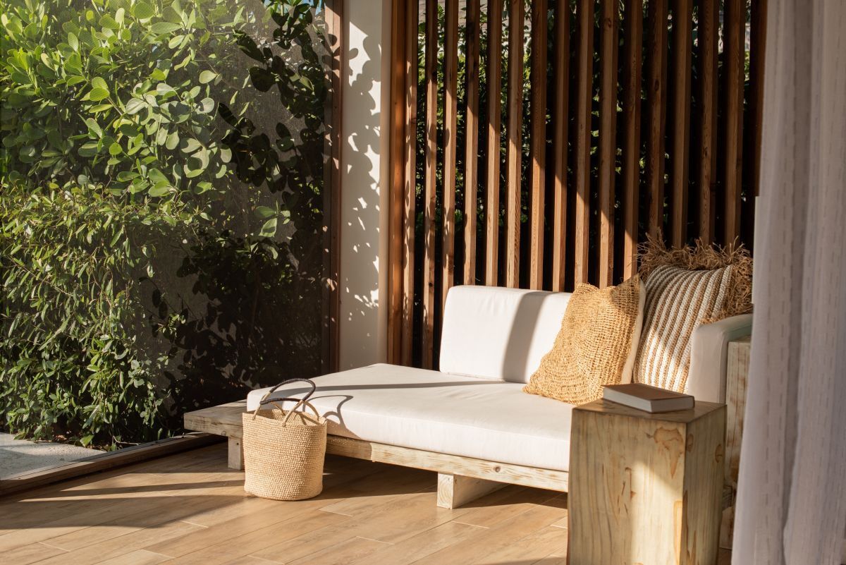a white couch with pillows and a table next to a window