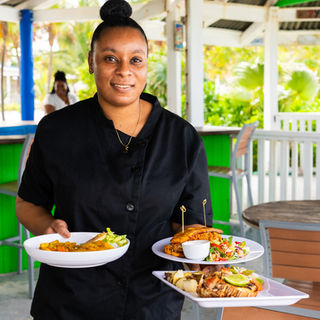 a woman holding plates of food