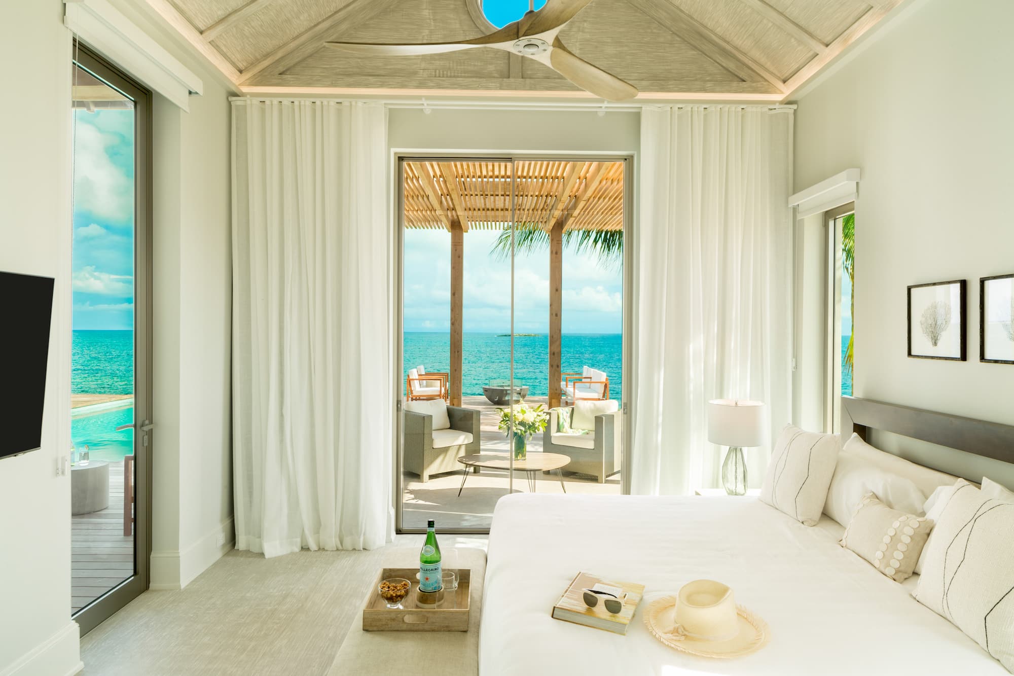 a room with a bed and a window with a view of the ocean