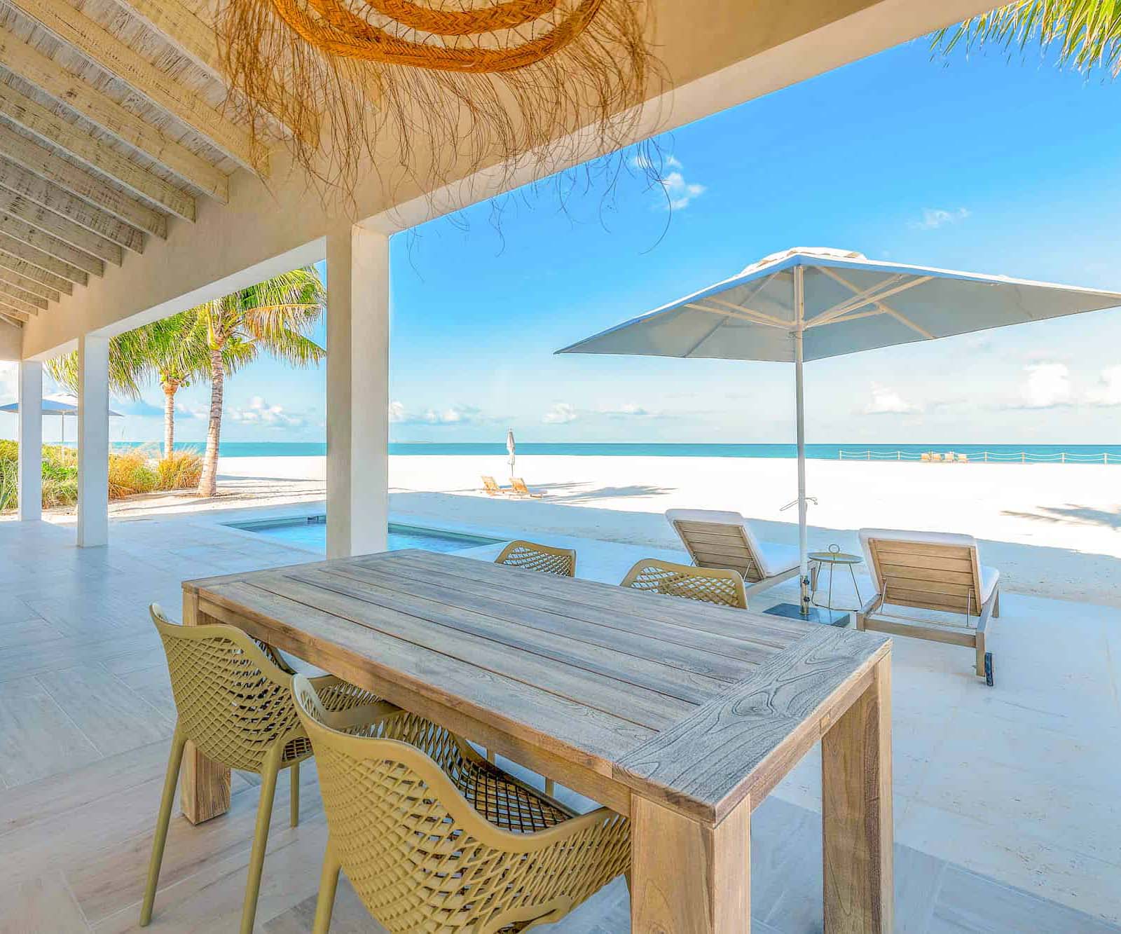 a table and chairs on a patio overlooking a beach