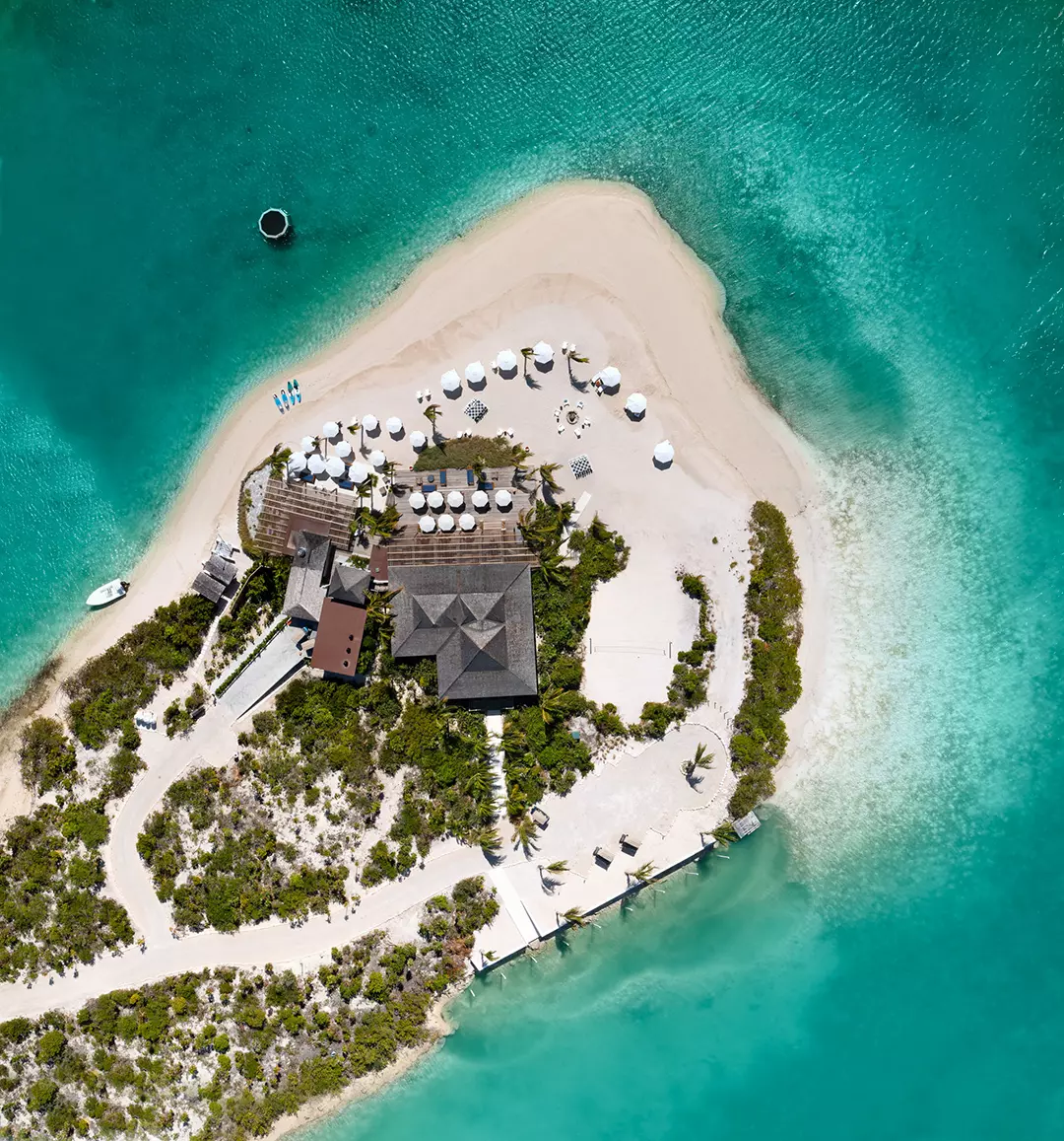 an island with a building and umbrellas
