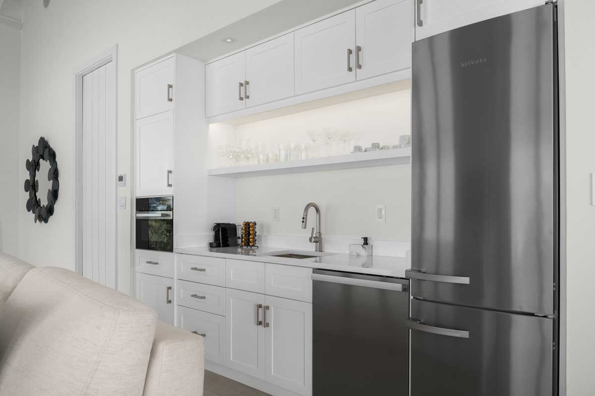 a kitchen with white cabinets and a refrigerator