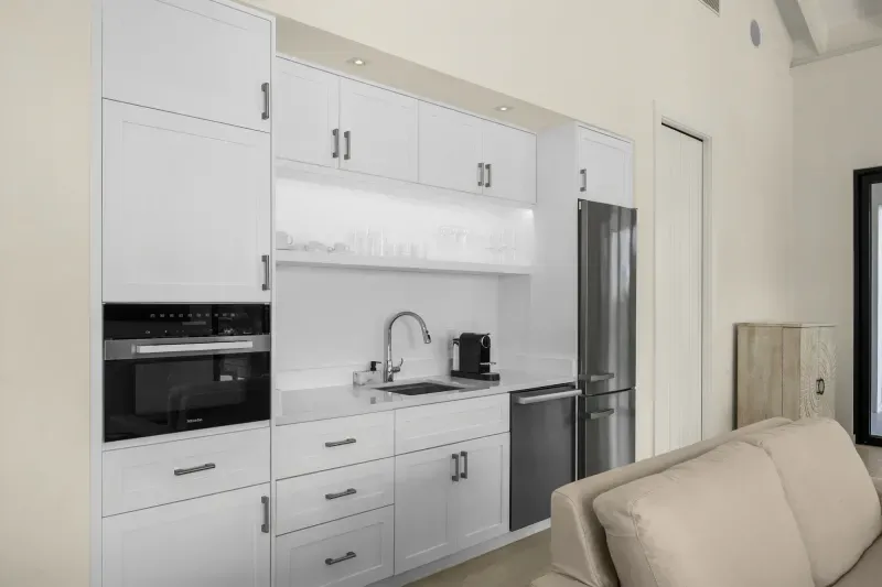 a kitchen with white cabinets and a couch