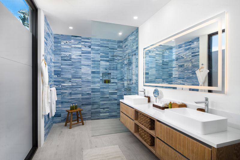 a bathroom with blue tile walls and white countertops