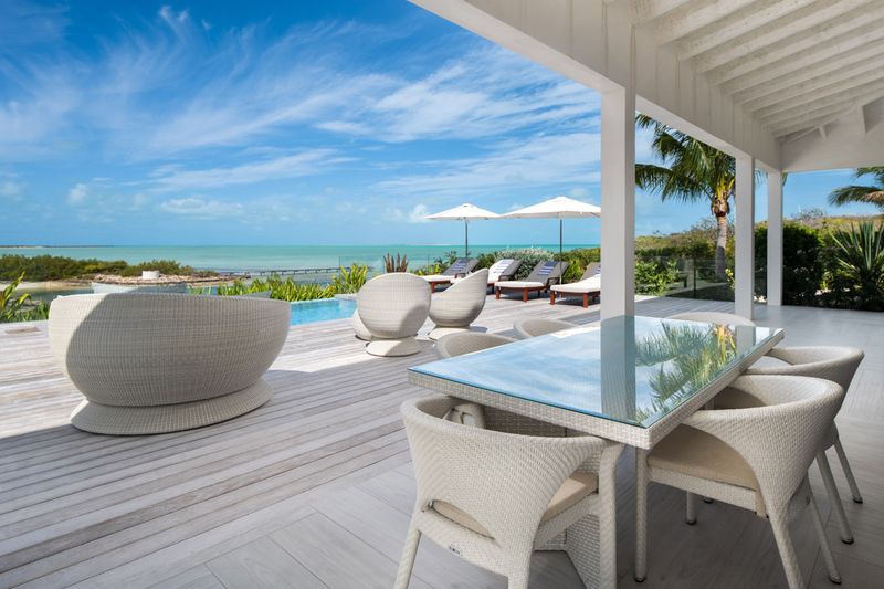 a patio with a table and chairs and a pool
