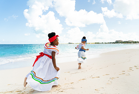 a couple of young girls running on a beach