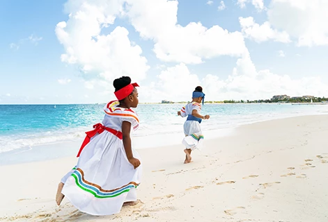 a couple of young girls running on a beach