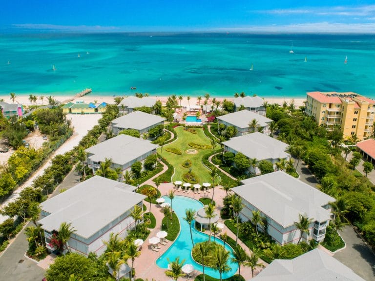 a group of buildings with a pool and a body of water