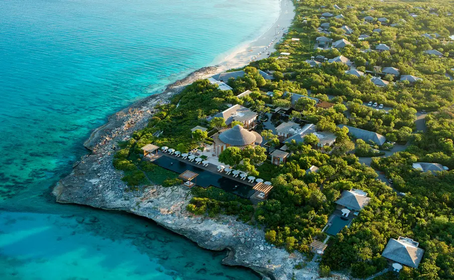 a aerial view of a beach with a building and trees