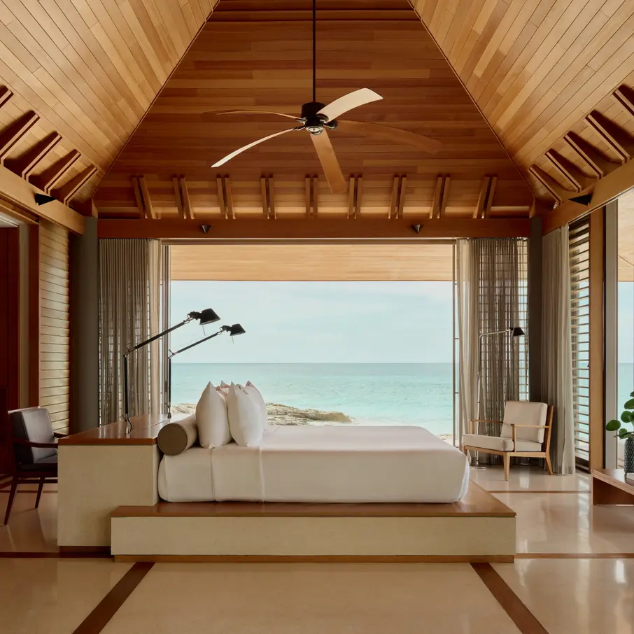 a room with a large bed and a ceiling fan