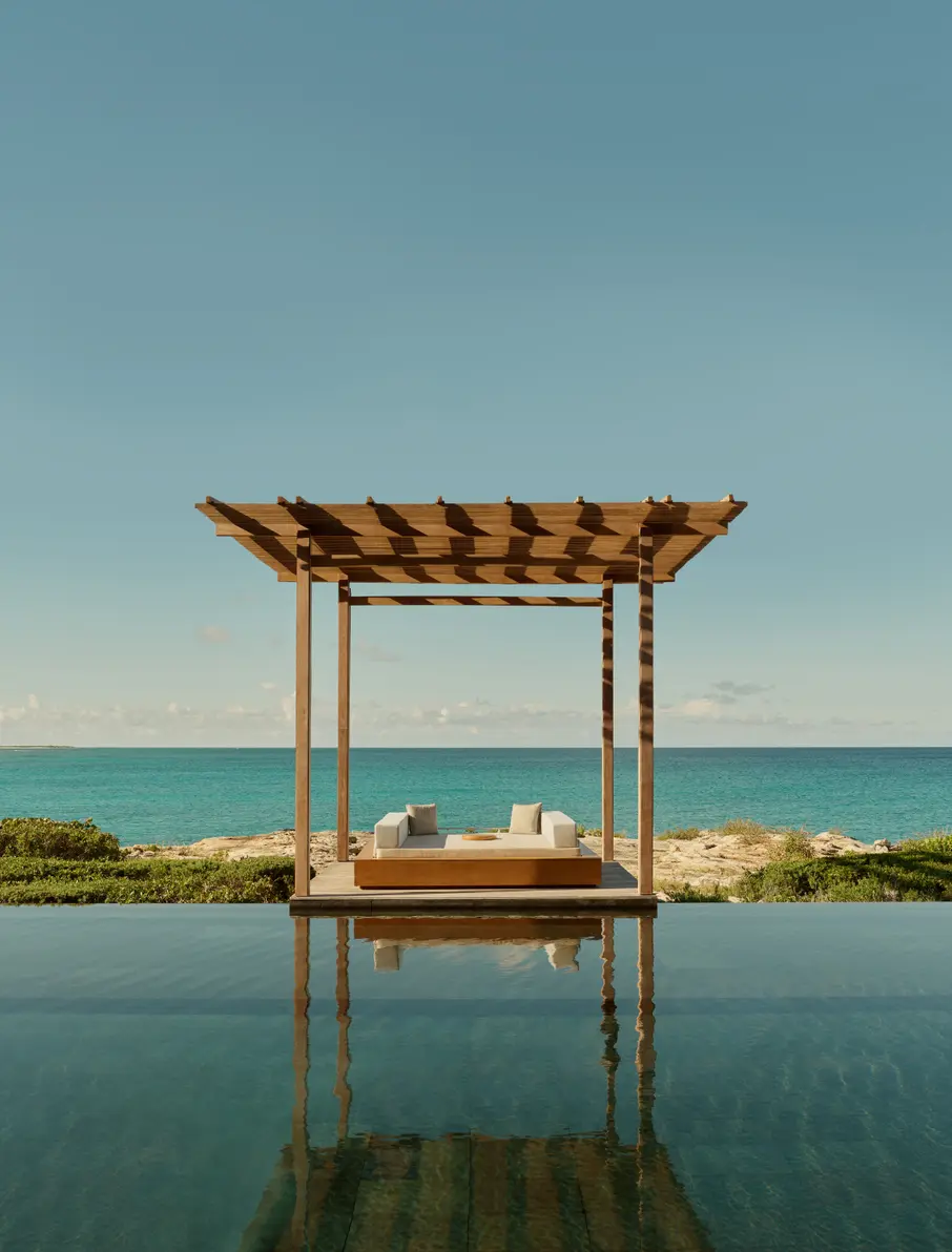 a pool with a bed and a beach view