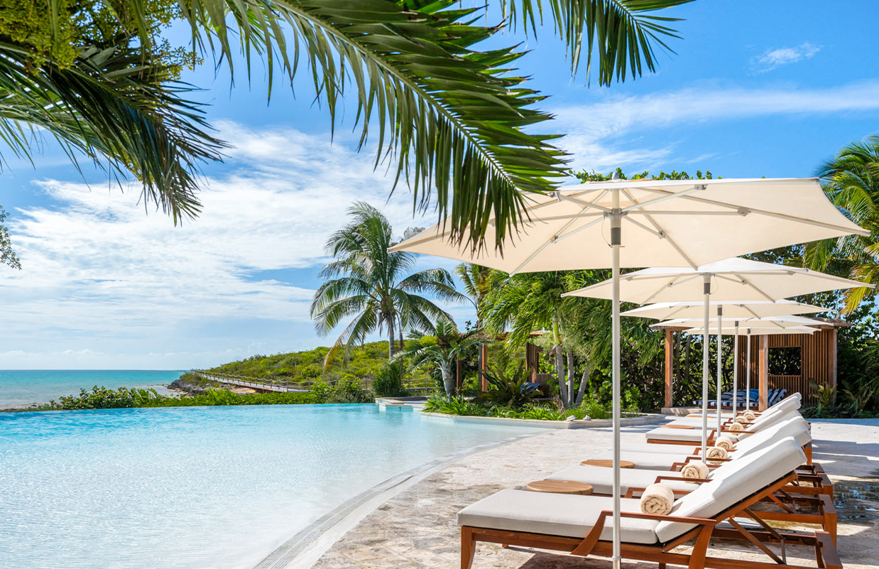 a pool with lounge chairs and umbrellas