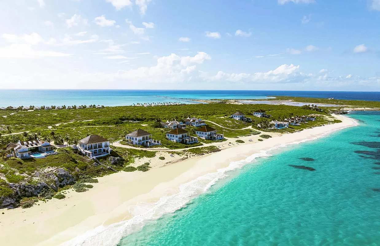 a beach with houses and a body of water