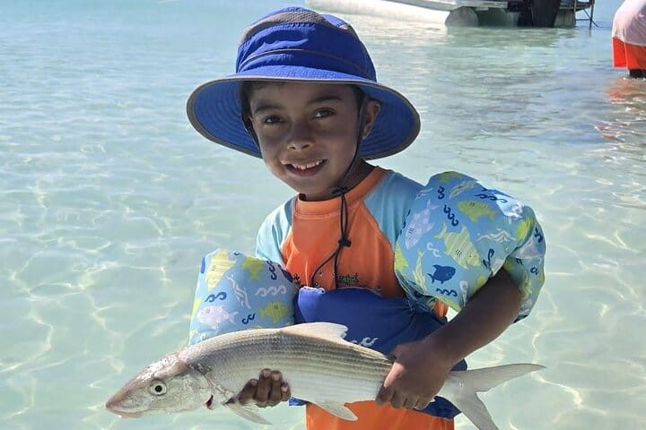 a boy holding a fish in water