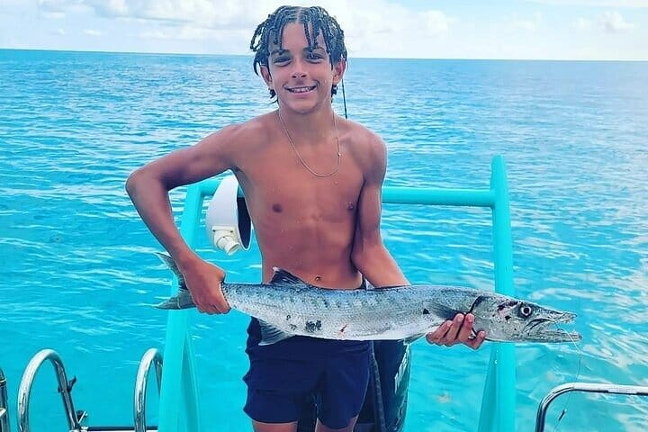 a boy holding a fish