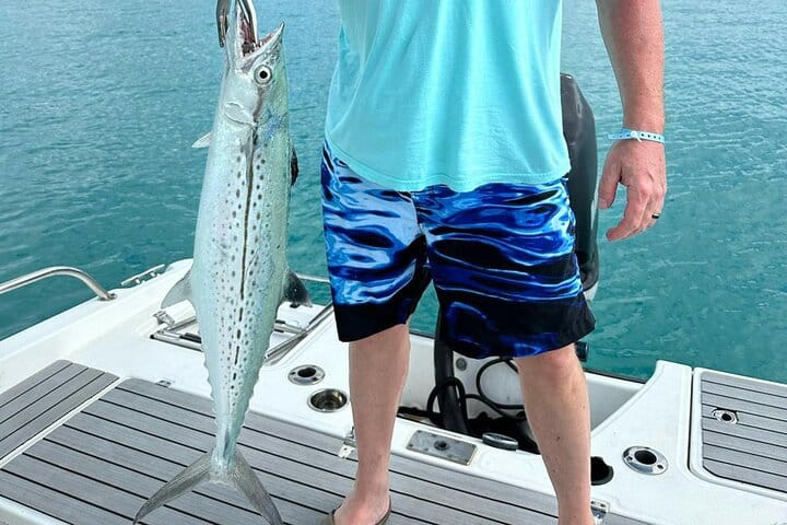 a man holding a fish on a boat