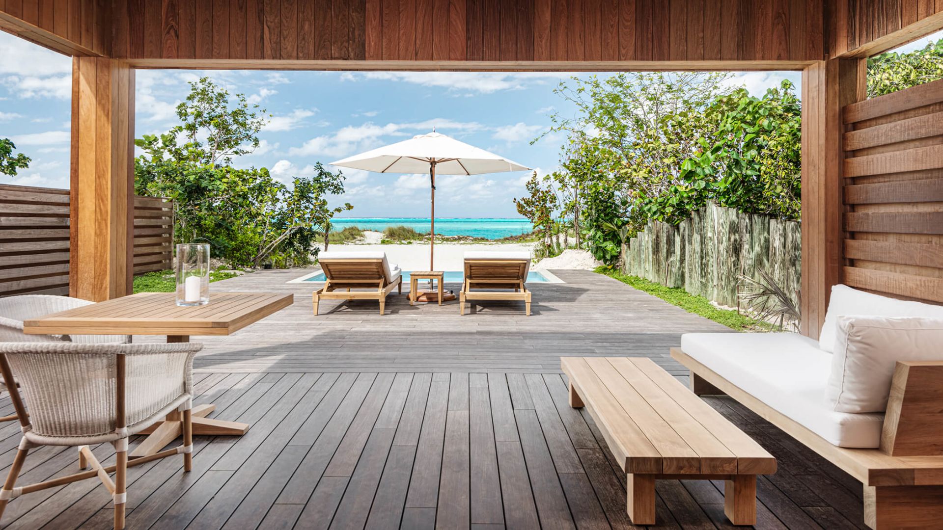 a deck with chairs and umbrellas on a beach
