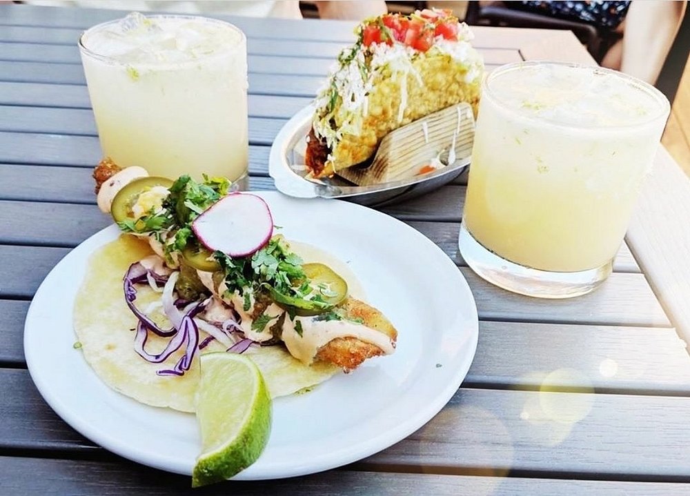 a plate of tacos and a drink on a table