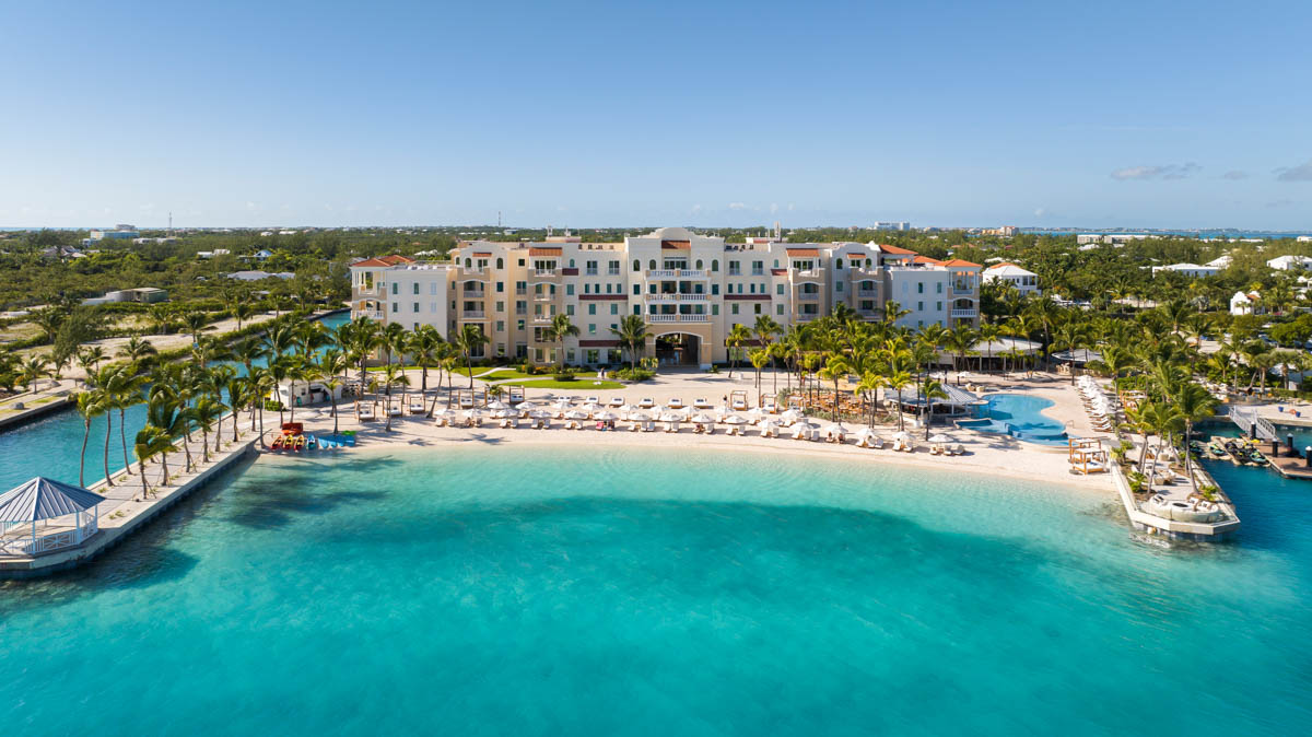 a large building with a beach and a body of water