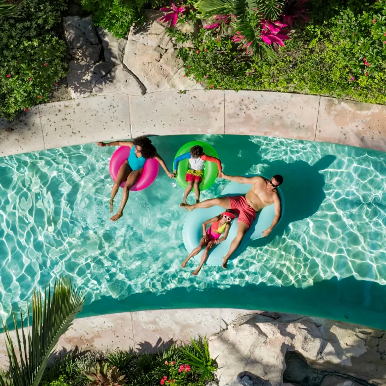 a group of people floating on inner tubes in a pool