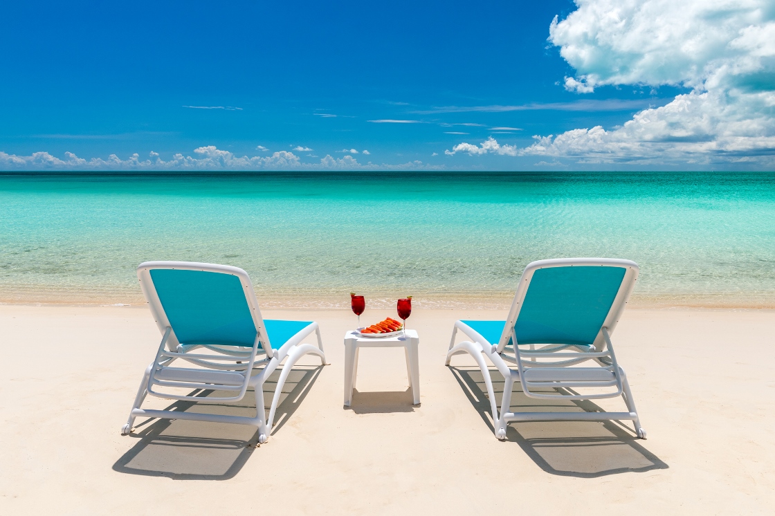 chairs on a beach with a tray of drinks