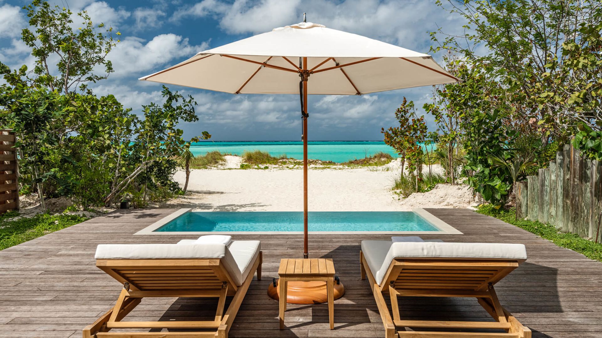 a pool with a deck chair and umbrella