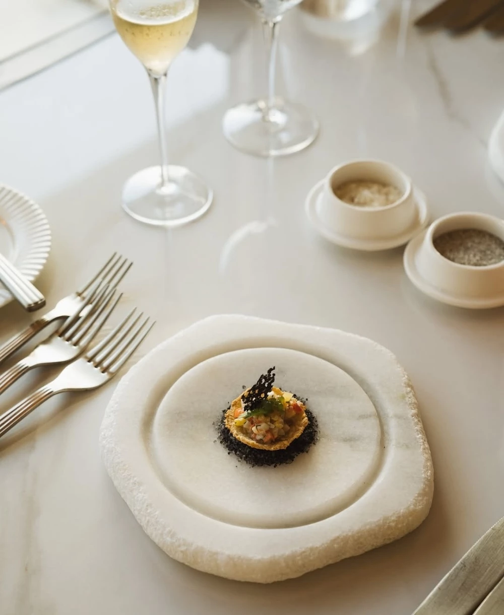 a plate with food on it next to a glass of wine