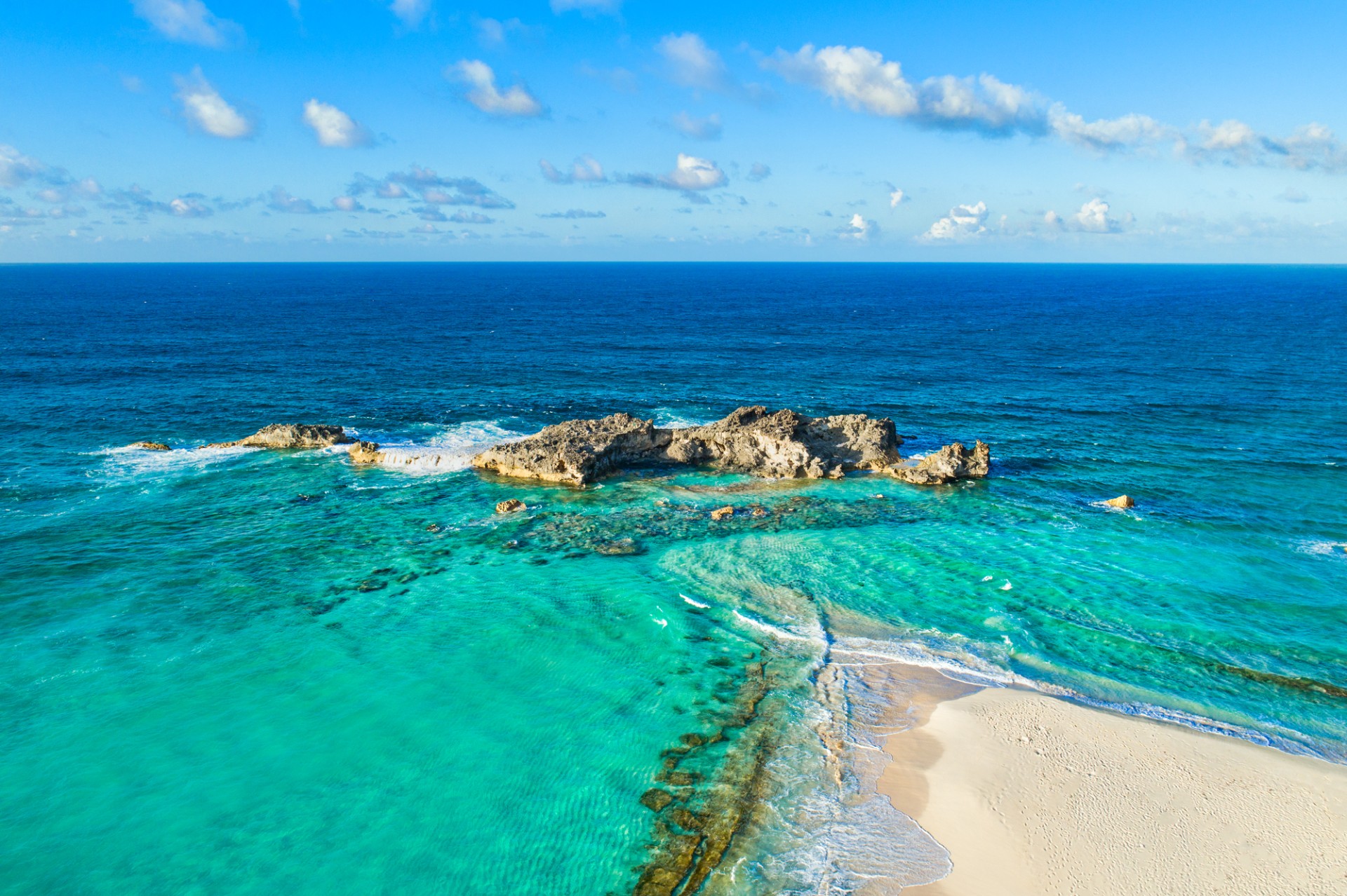 a beach with rocks in the water