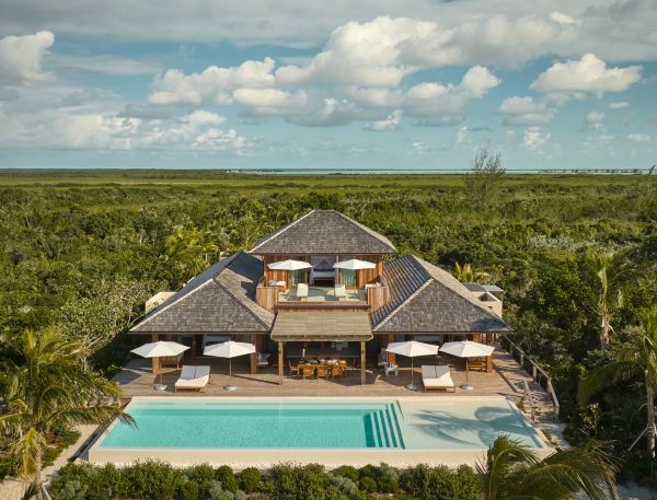 a house with a pool in the middle of a field