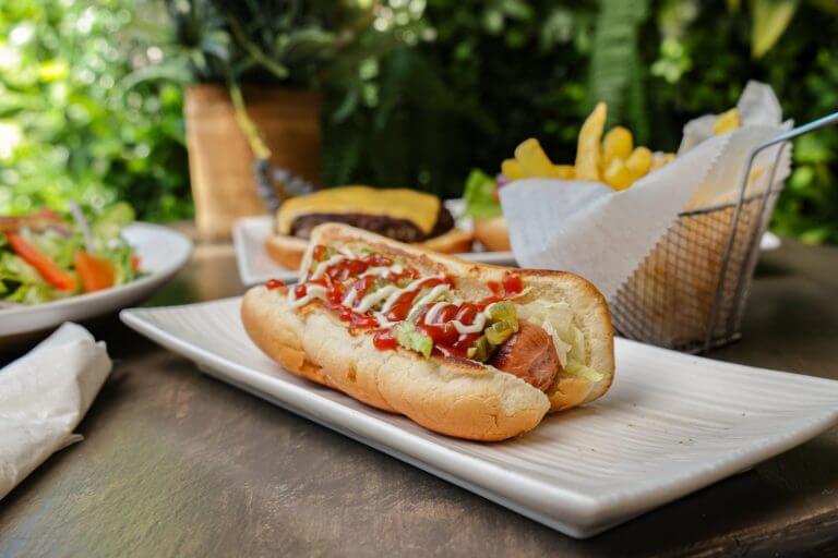 a hot dog with ketchup and mustard on a white plate