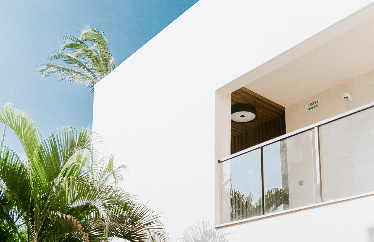 a balcony with a glass railing and palm trees