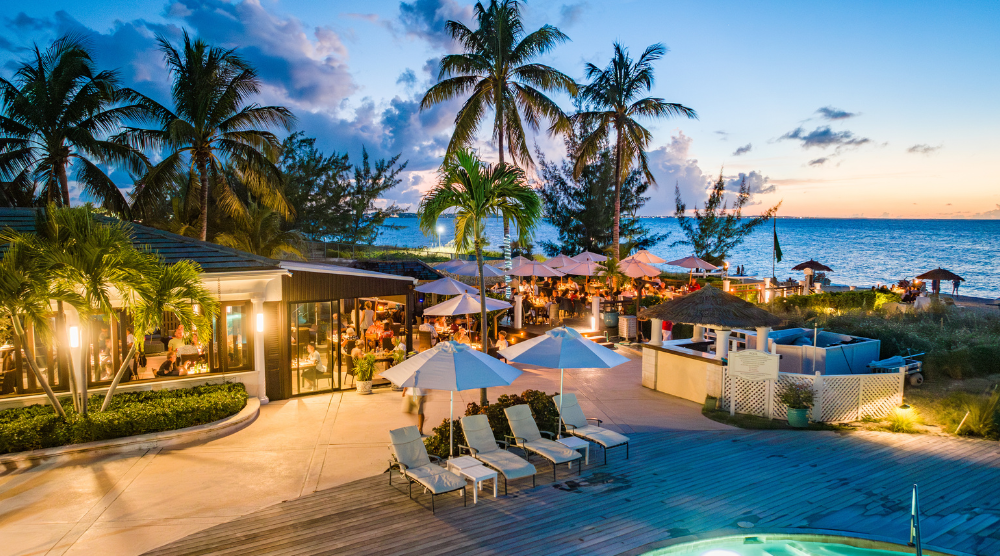a pool with umbrellas and chairs and palm trees